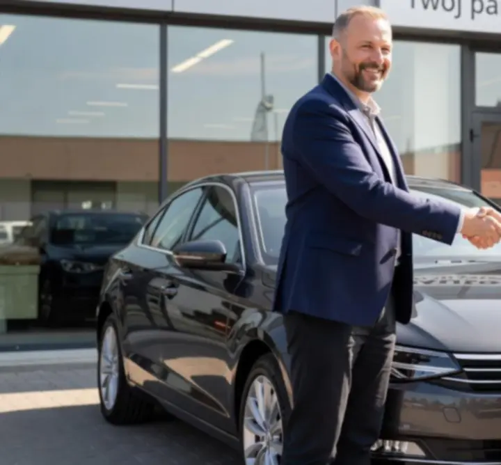 Zadowoleni klienci odbierający nowo zakupiony samochód